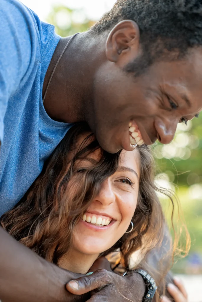 Ερωτευμένο ζευγάρι αγκαλιάζεται και γελά με φυσικό φως σε εξωτερικό χώρο