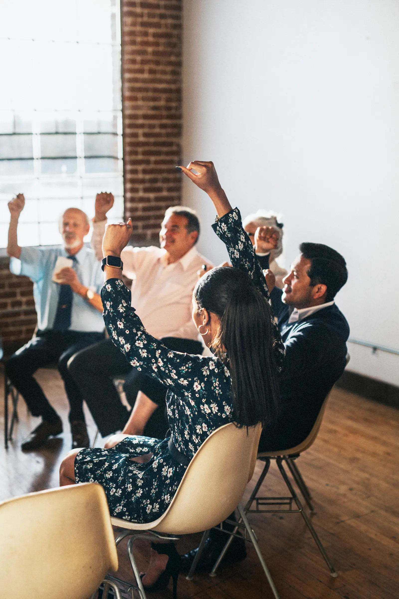 Ομάδα ανθρώπων σε κύκλο σηκώνει τα χέρια πανηγυρίζοντας σε ομαδική συνεδρία